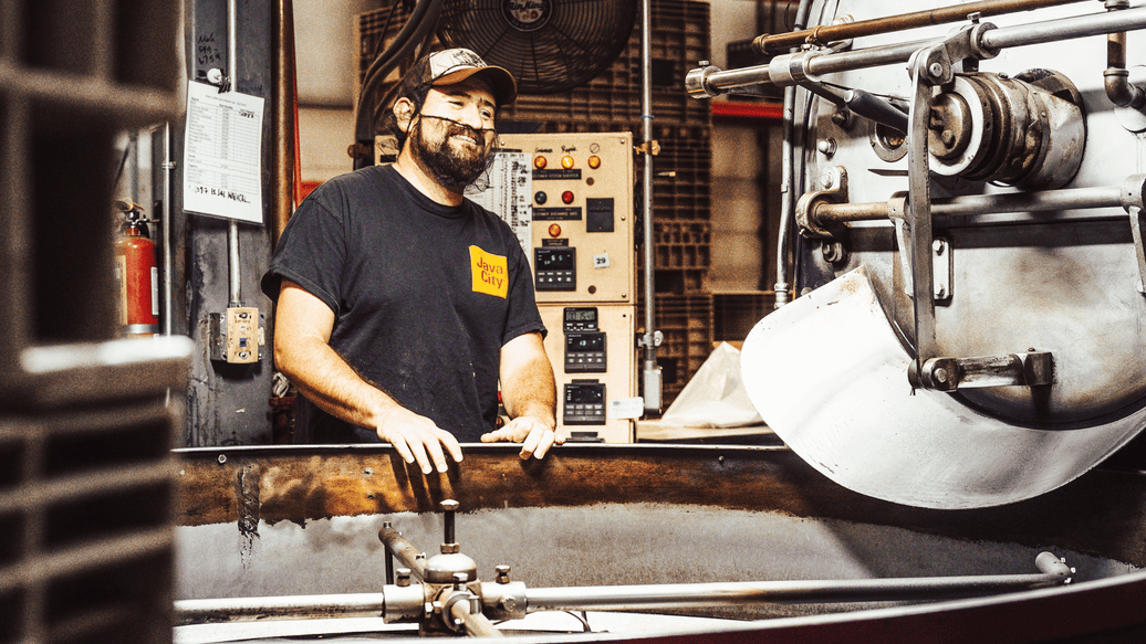 Coffee roaster, Julio, posing by the roaster at Java City's facility in Sacramento