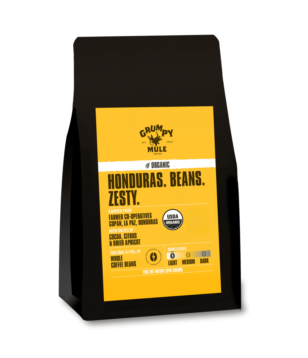 Coffee bag with yellow label featuring 'Grumpy Mule' branding on a transparent background