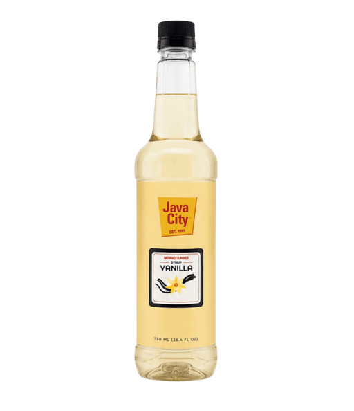 A bottle of Java City Vanilla Extract syrup on a solid dark green background. The clear bottle shows the pale yellow liquid inside, with a yellow and white label featuring vanilla bean illustrations and a black cap.