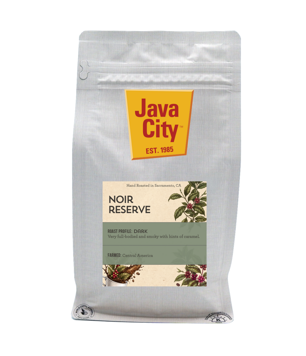 A silver stand-up coffee bag labeled Java City Noir Reserve, with a yellow brand panel and a cream-and-green product label, photographed on a white background.
