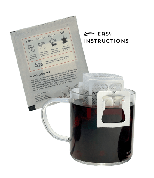 Clear glass mug with a white filter basket filled with dark liquid, next to a paper package with brewing instructions for single-serve pour over on a transparent background.